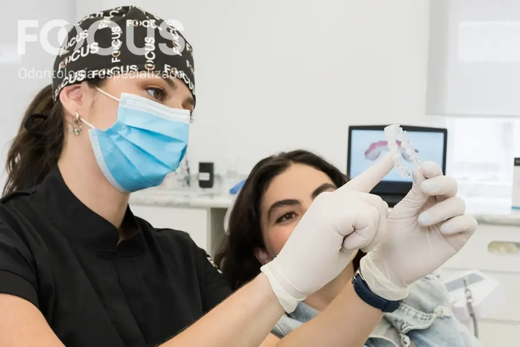 Especialista de FOCUS explica a una paciente qué es una endodoncia con un modelo dental