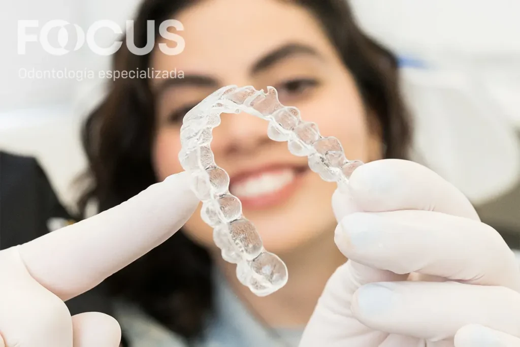 Ortodoncista explica a una paciente adulta las opciones de brackets en una consulta